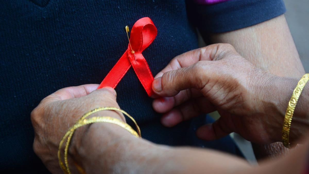 Una persona porta el lazo rojo con motivo del Día Mundial de la Lucha contra el Sida.