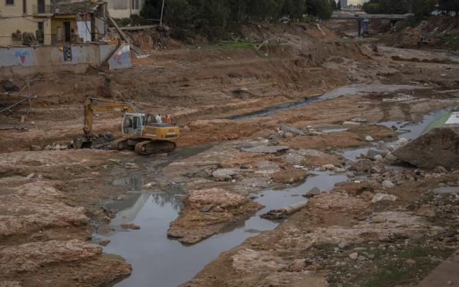 Una máquina trabaja en las labores de limpieza y desescombro en el barranco del Poyo