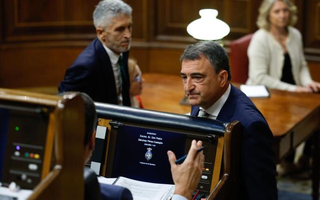 El portavoz del PNV en el Congreso, Aitor Esteban, conversa con el presidente del Gobierno español, Pedro Sánchez, de espaldas en su escaño