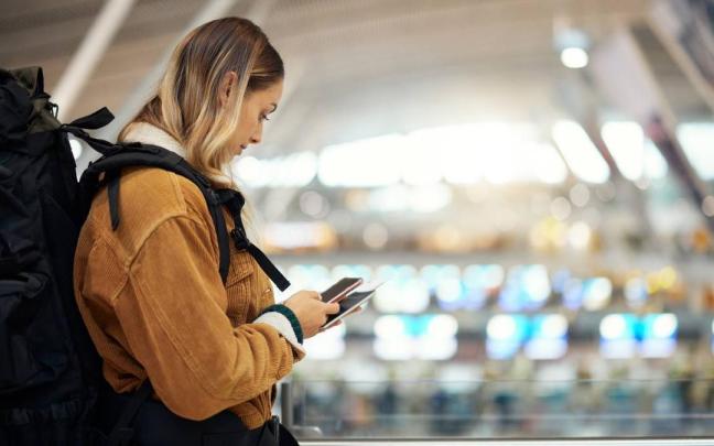 Una mujer en el aeropuerto antes de realizar un viaje.