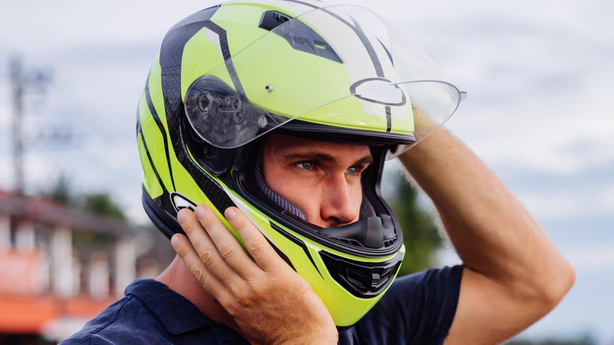 Un hombre se ajusta el casco de moto.