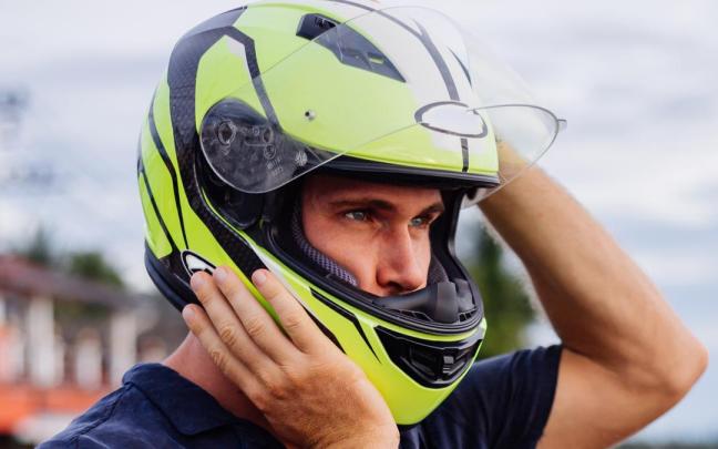 Un hombre se ajusta el casco de moto.