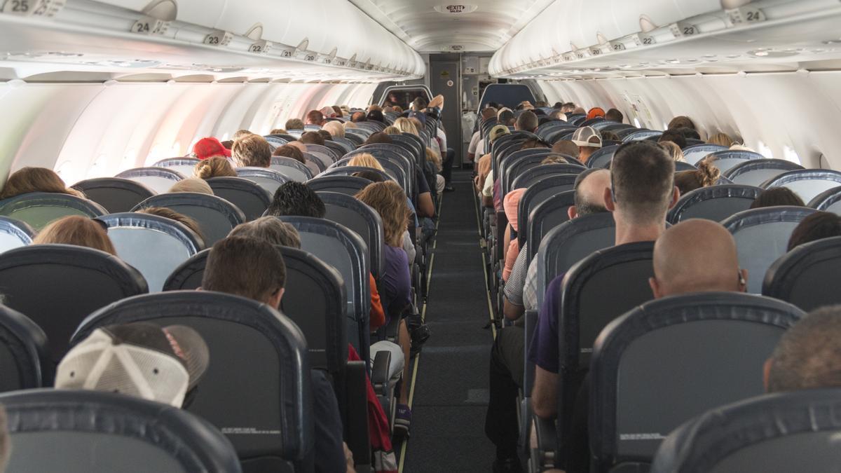 Pasajeros sentados dentro de un avión.