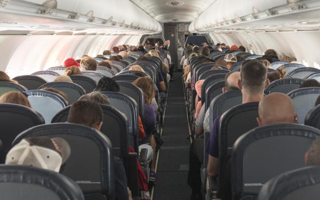 Pasajeros sentados dentro de un avión.