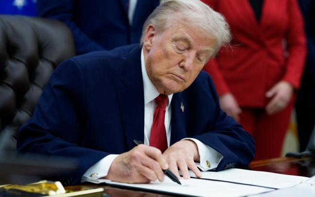 Trump firma un documento en una imagen de archivo.