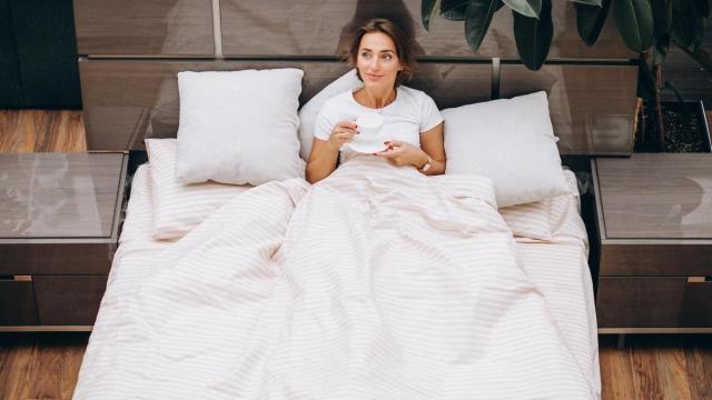 Joven mujer descansando en la cama por la mañana