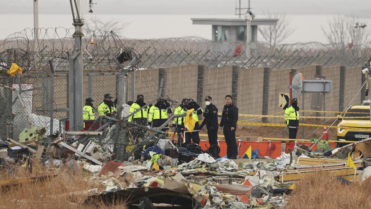 Policías surcoreanos investigan el lugar en el que se estrelló el vuelo 7C2216 de Jeju Air en Muan.