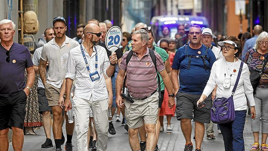 Un grupo de turistas sigue a un guía por el casco antiguo de Valencia. | FOTO: EFE