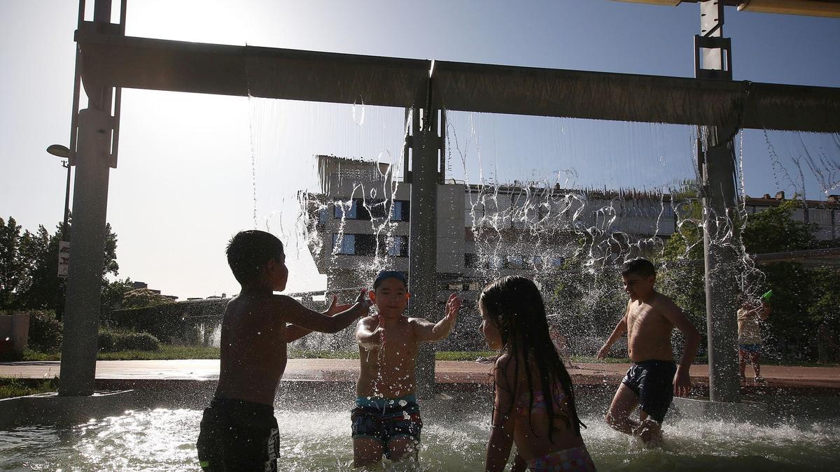 Varios niños se refrescan en las fuentes del parque de Yamaguchi ante las altas temperaturas.