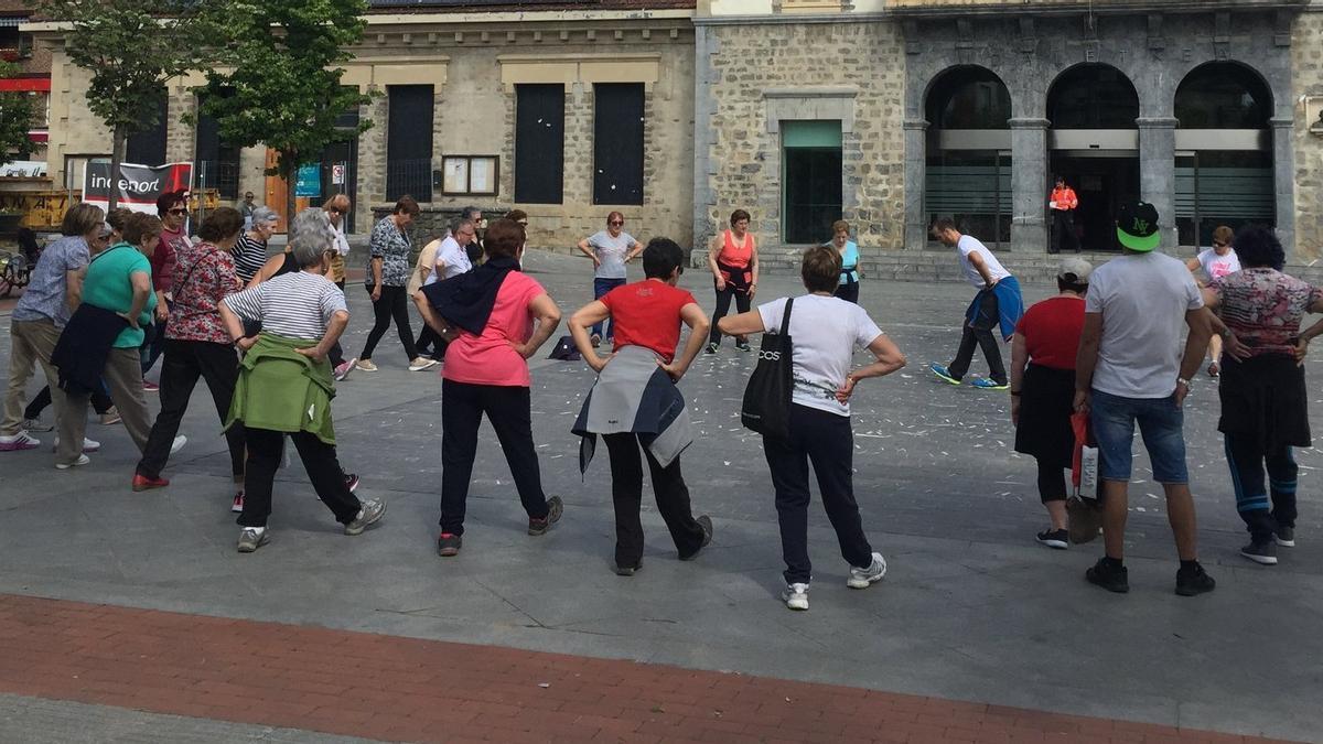 Mujeres mayores haciendo calentamientos con un guía profesional antes de salir a andar en Amurrio