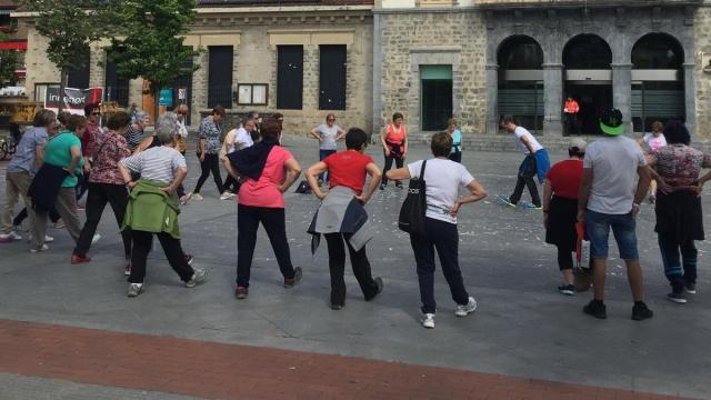 Mujeres mayores haciendo calentamientos con un guía profesional antes de salir a andar en Amurrio
