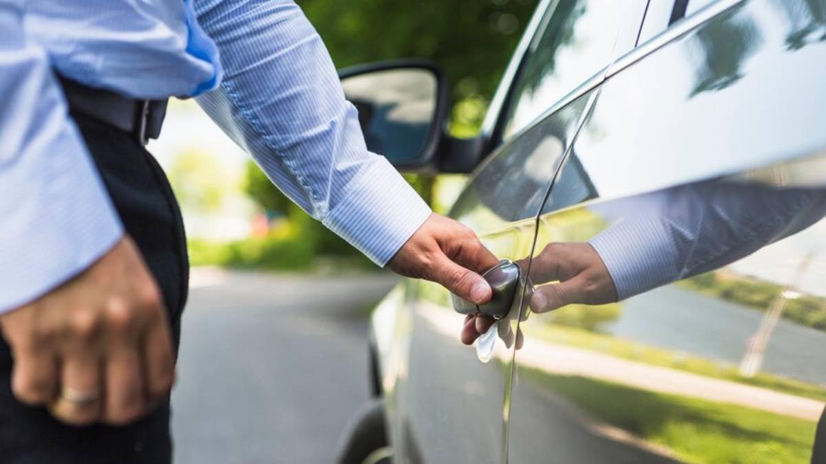 Conductor abre la puerta del coche