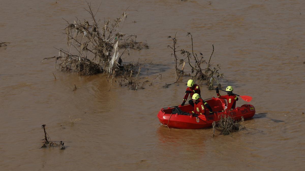 Bomberos y miembros de la UME buscan a víctimas en el río Turia.