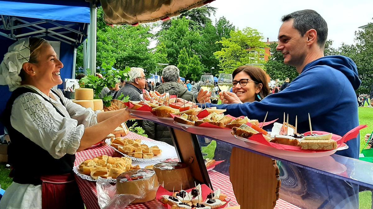 Una pareja brinda con txakoli ante un stand de queso en la pasada edición