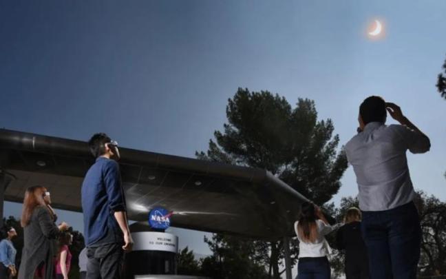 Personas contemplando un eclipse solar.