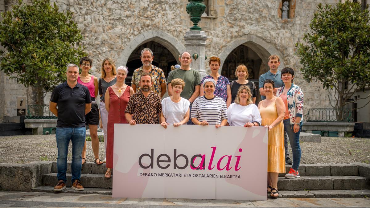 Comerciantes y hosteleros de Deba, posando con el logo que identifica a hora a Debalai.