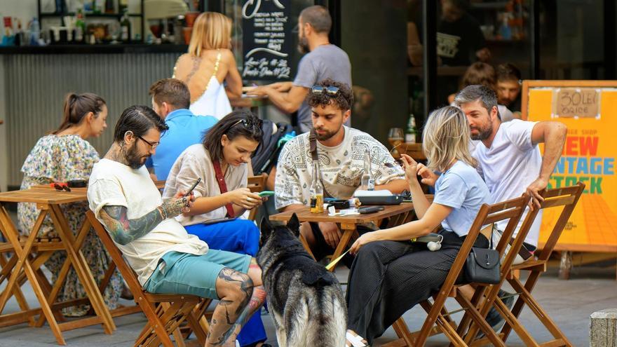 Turistas usan sus teléfonos en un restaurante.