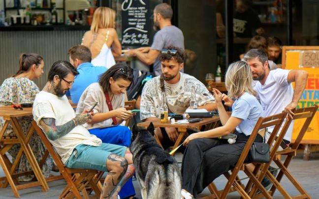 Turistas usan sus teléfonos en un restaurante. Turistas usan sus teléfonos en un restaurante.
