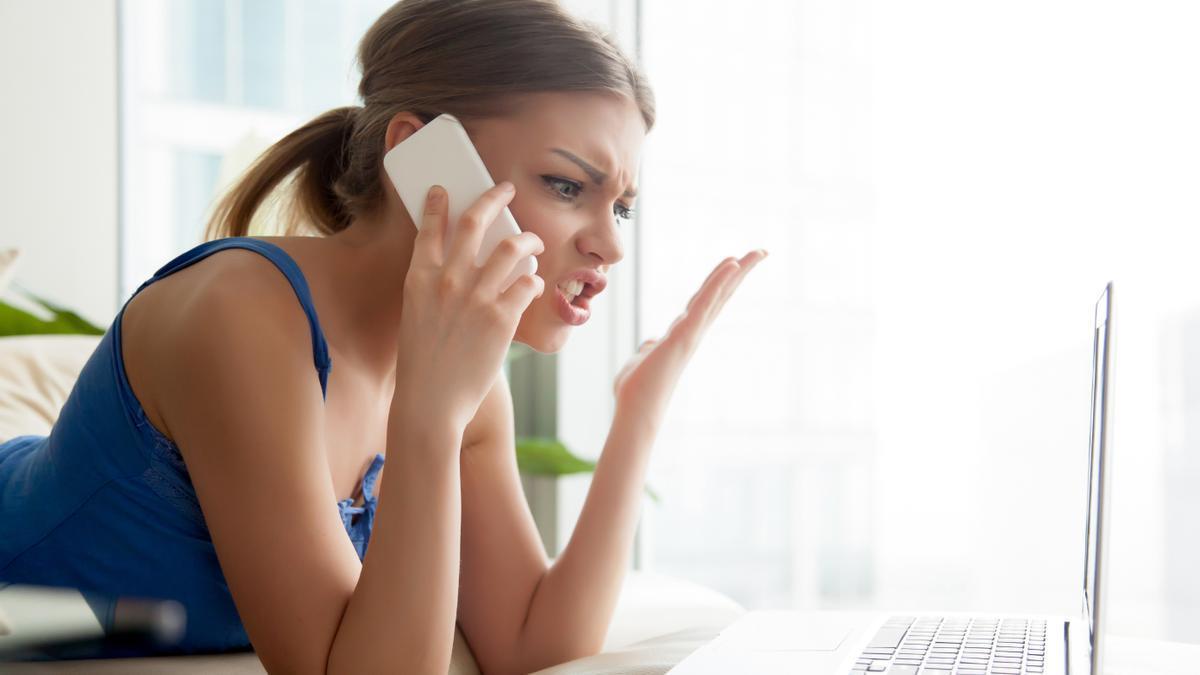 Una mujer atiende enfadada a una llamada comercial desde su móvil.