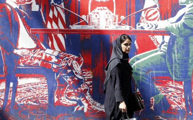 Una mujer camina por Teherán con el velo puesto.