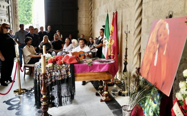 Un hombre, guitarra en mano, canta a la artista María Jiménez en la Capilla Ardiente instalada en el Ayuntamiento de Sevilla.