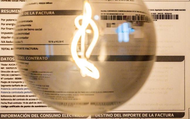 Una bombilla encendida frente a una factura de luz.
