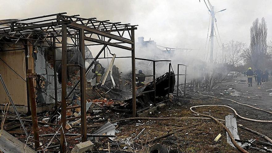 Un grupo de bomberos inspeccionan los restos de un edificio atacado por las tropas rusas en Járkov. | FOTO: EFE