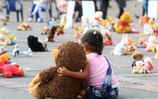 Una niña abraza un muñeco durante un “plantón de juguetes” organizado por Aldeas Infantiles en contra del abuso sexual ifantil.