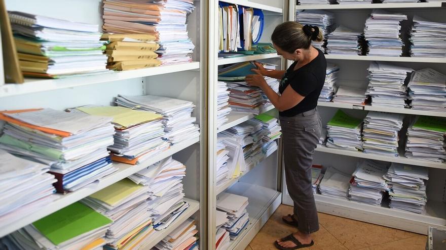 Una mujer, ajena a esta información, revisando expedientes guardados en carpetas.