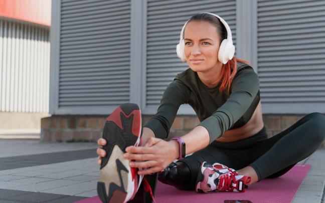 Una mujer hace ejercicio físico con música Freepik