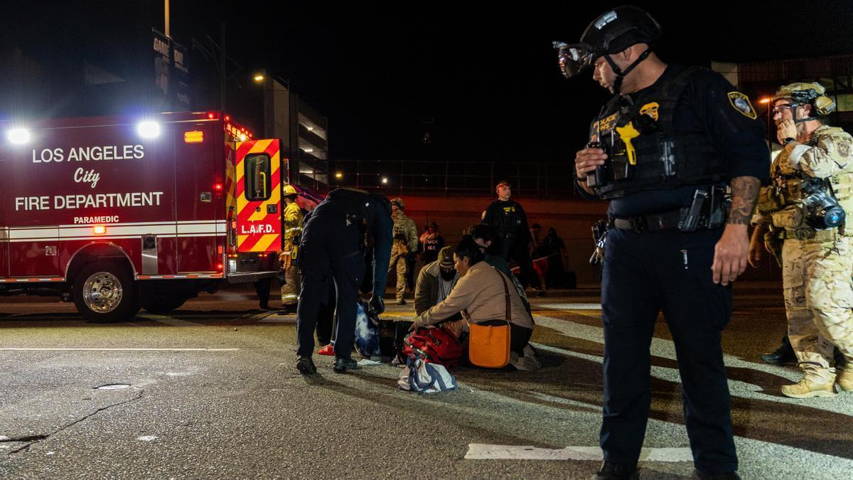 Emergencias sanitarias atienden a una mujer herida en las protestas contra el ICE.