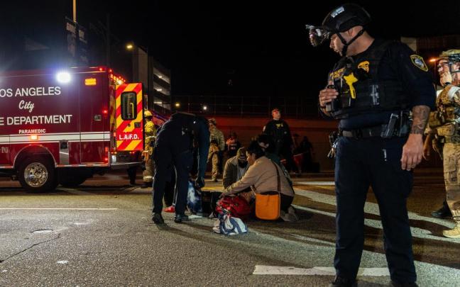 Emergencias sanitarias atienden a una mujer herida en las protestas contra el ICE.