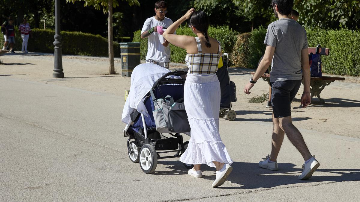 Dos jóvenes con niños paseando por un parque