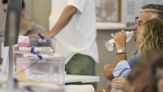Un miembro de una mesa electoral en Andalucía se refresca bebiendo agua.