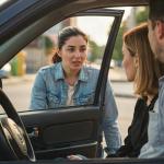 Una pareja pregunta algo desde el coche a una joven.