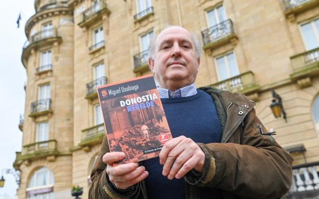 Miguel Usabiaga posa con su libro 'Donostia rebelde' delante del María Cristina.