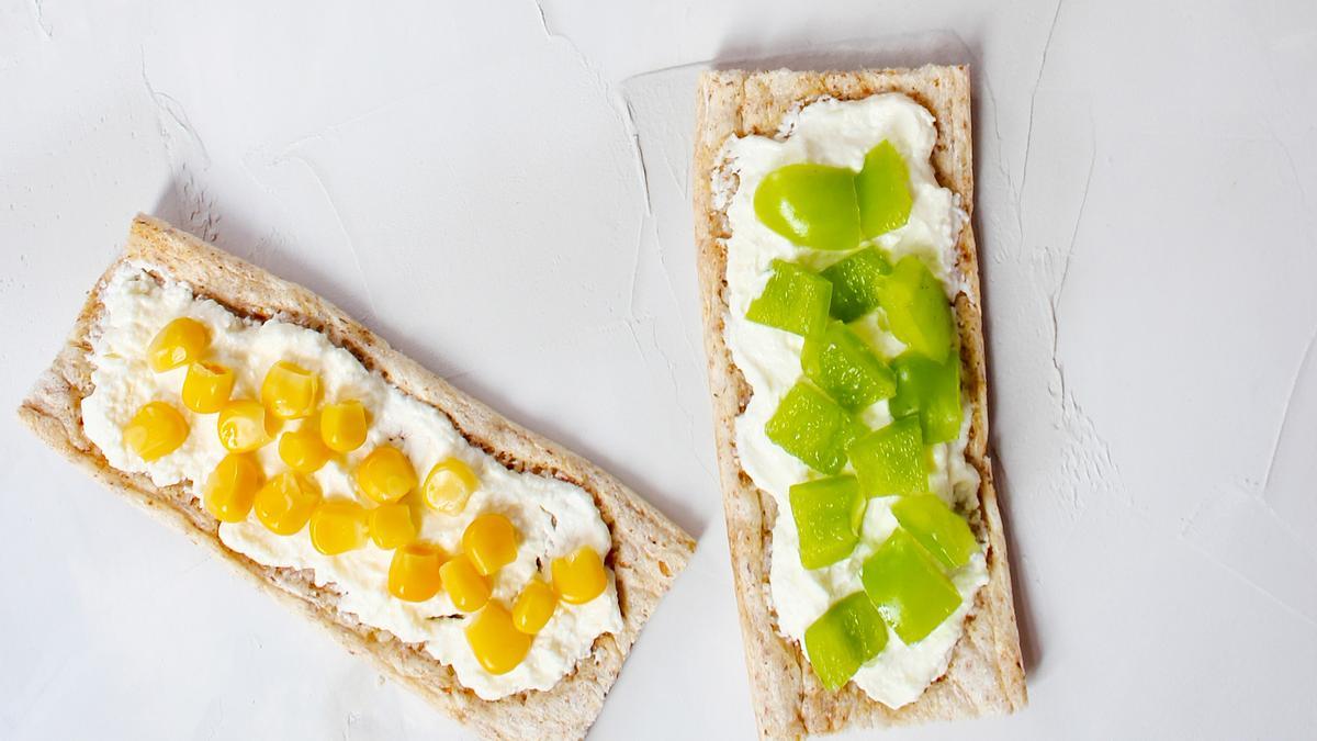 Tostadas con queso fresco y fruta o verdura troceada.
