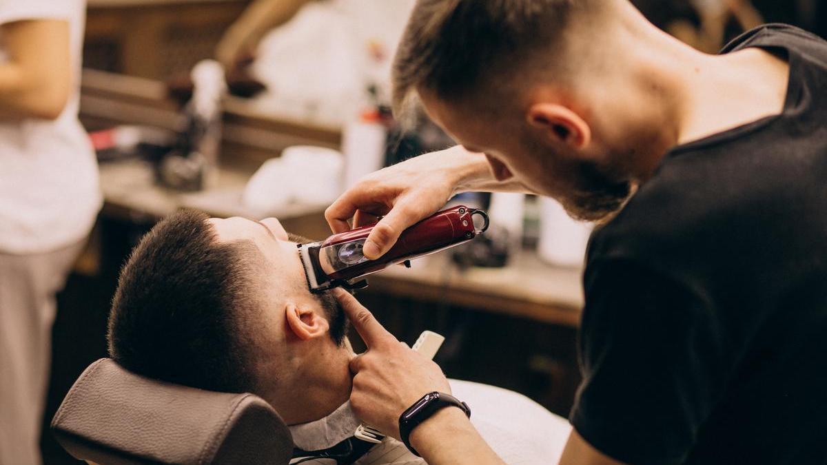 Un barbero con un cliente en una peluquería.