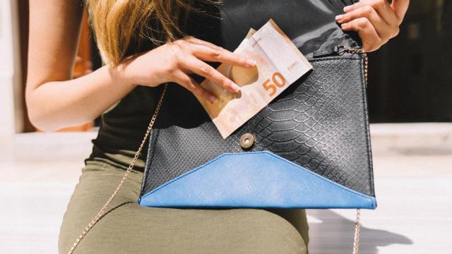Una mujer saca dinero de la cartera