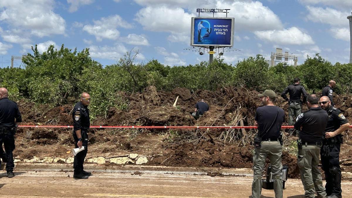 Soldados y policías israelíes junto a la zona del aeropuerto de Tel Aviv en la que cayó el misil.
