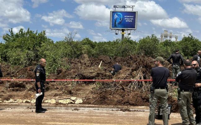 Soldados y policías israelíes junto a la zona del aeropuerto de Tel Aviv en la que cayó el misil.