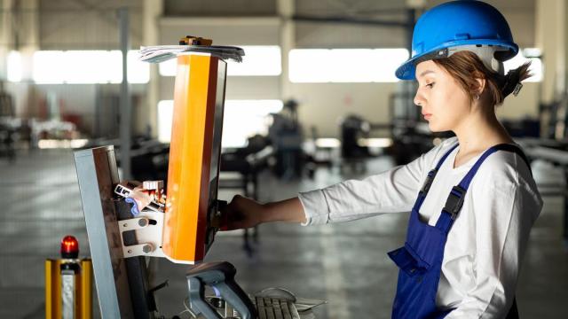 Una mujer maneja una máquina en una empresa.
