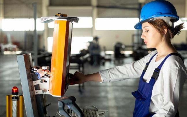 Una mujer maneja una máquina en una empresa.