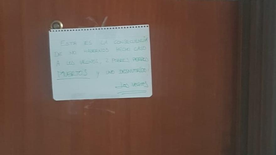 Imagen de la puerta en la que los vecinos de Igorre han colocado el cartel de denuncia por los perros muertos en un piso