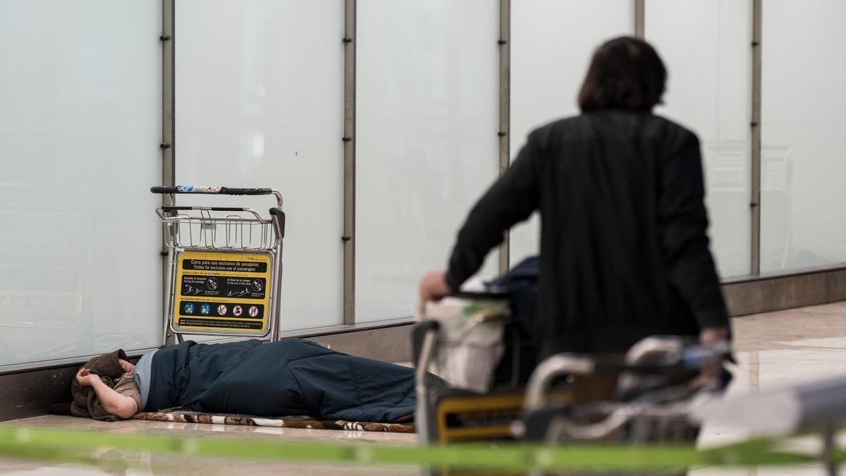 Una persona sin hogar en el aeropuerto de Barajas.