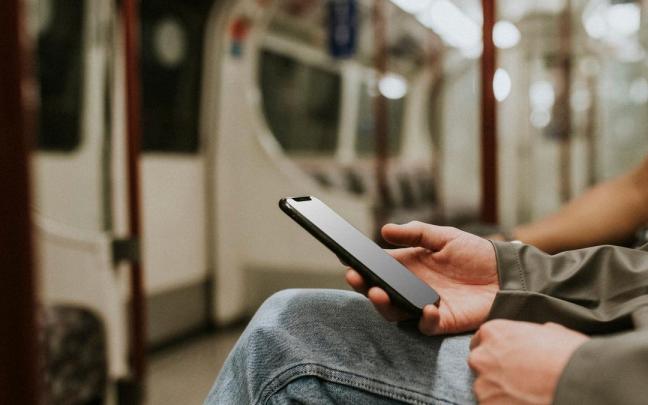 Un usuario del metro sostiene un móvil en la mano. Un usuario del metro sostiene un móvil en la mano.