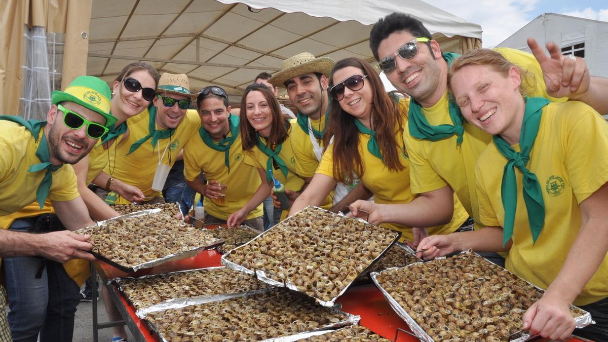 Grupo de peñistas mostrando sus bandejas de caracoles.