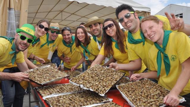 Grupo de peñistas mostrando sus bandejas de caracoles.