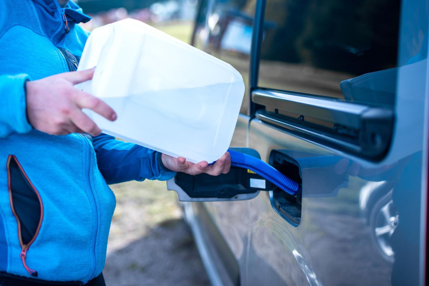 Una persona rellena el depósito de AdBlue con una garrafa.