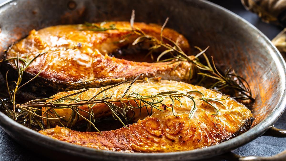 Dos rodajas de salmón cocinadas con romero, sal y pimienta.